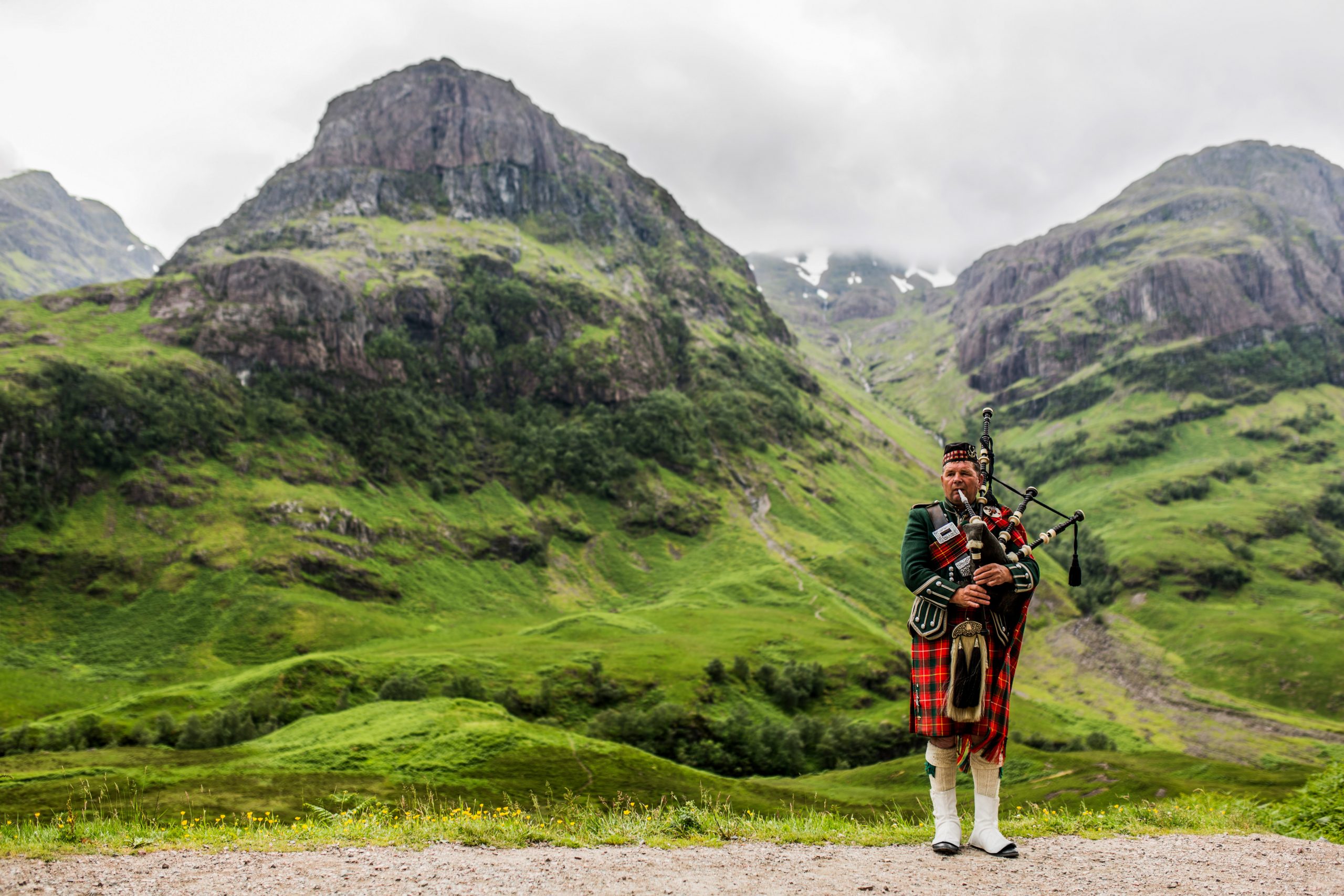 Scottish bagpiper in front of a mountain