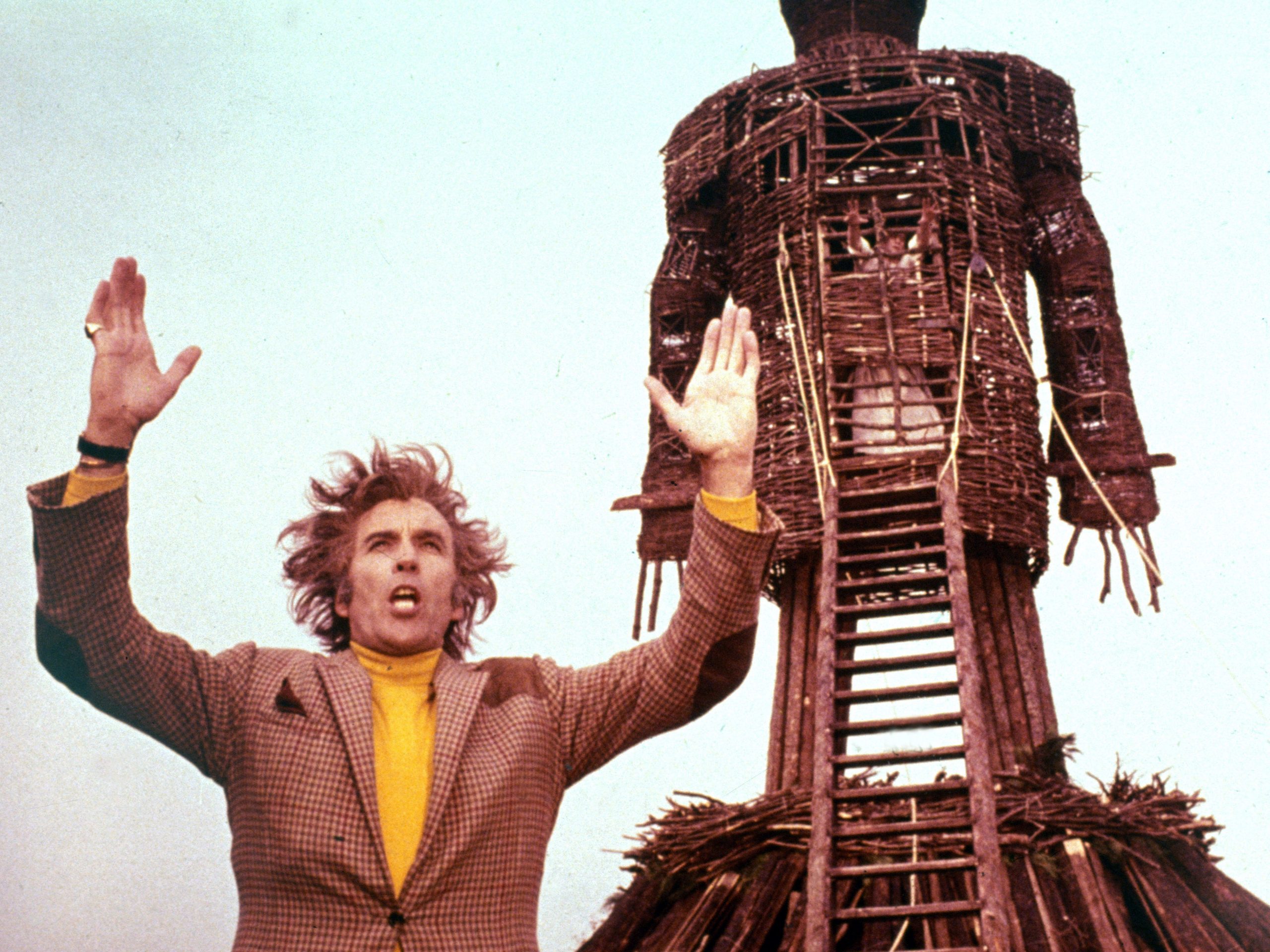A scene from the Wicker Man, with the actor standing in front of a large wicker statue