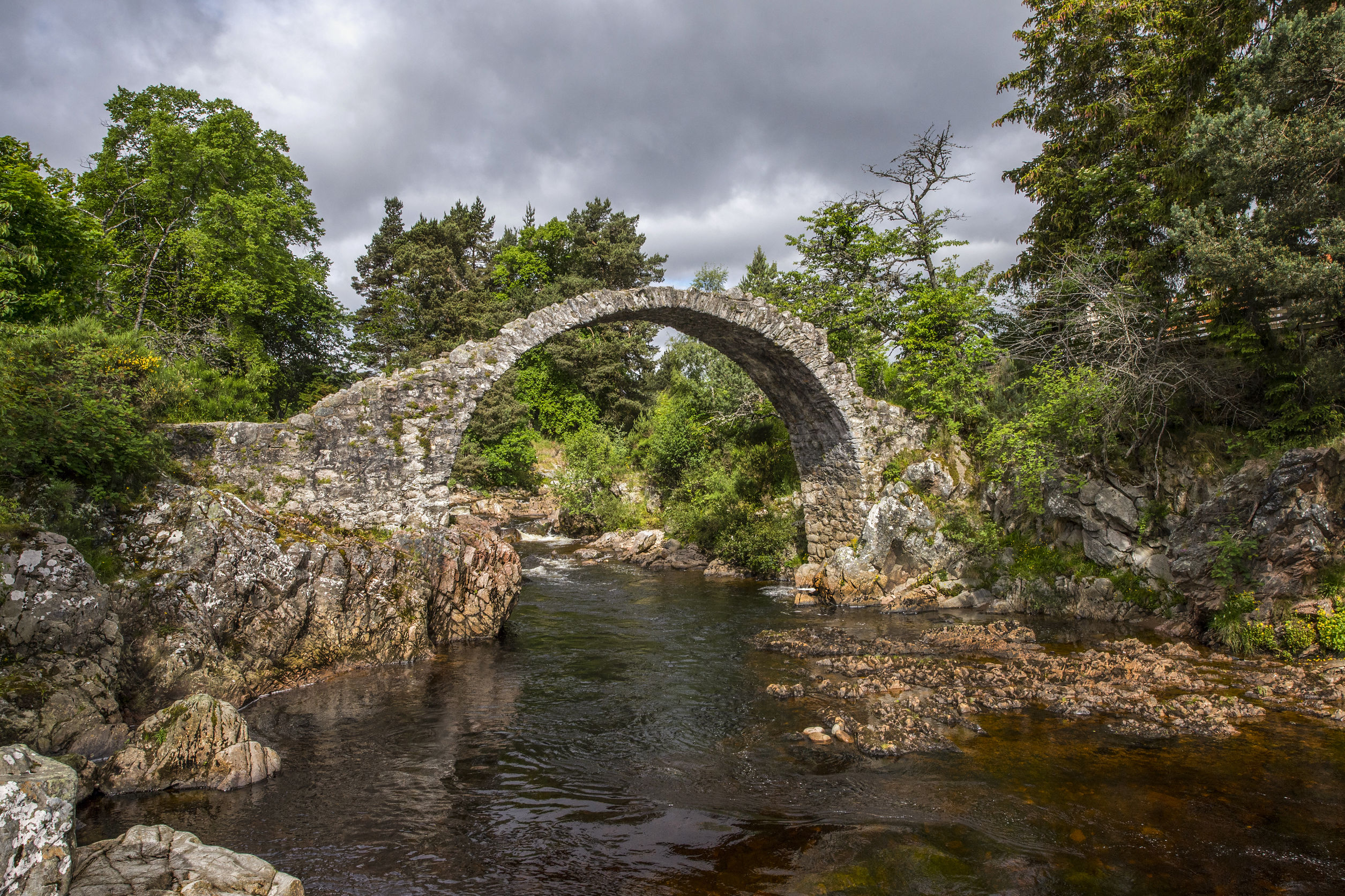 a view of the old packhorse bridge at carrbridge in the scottish highlands