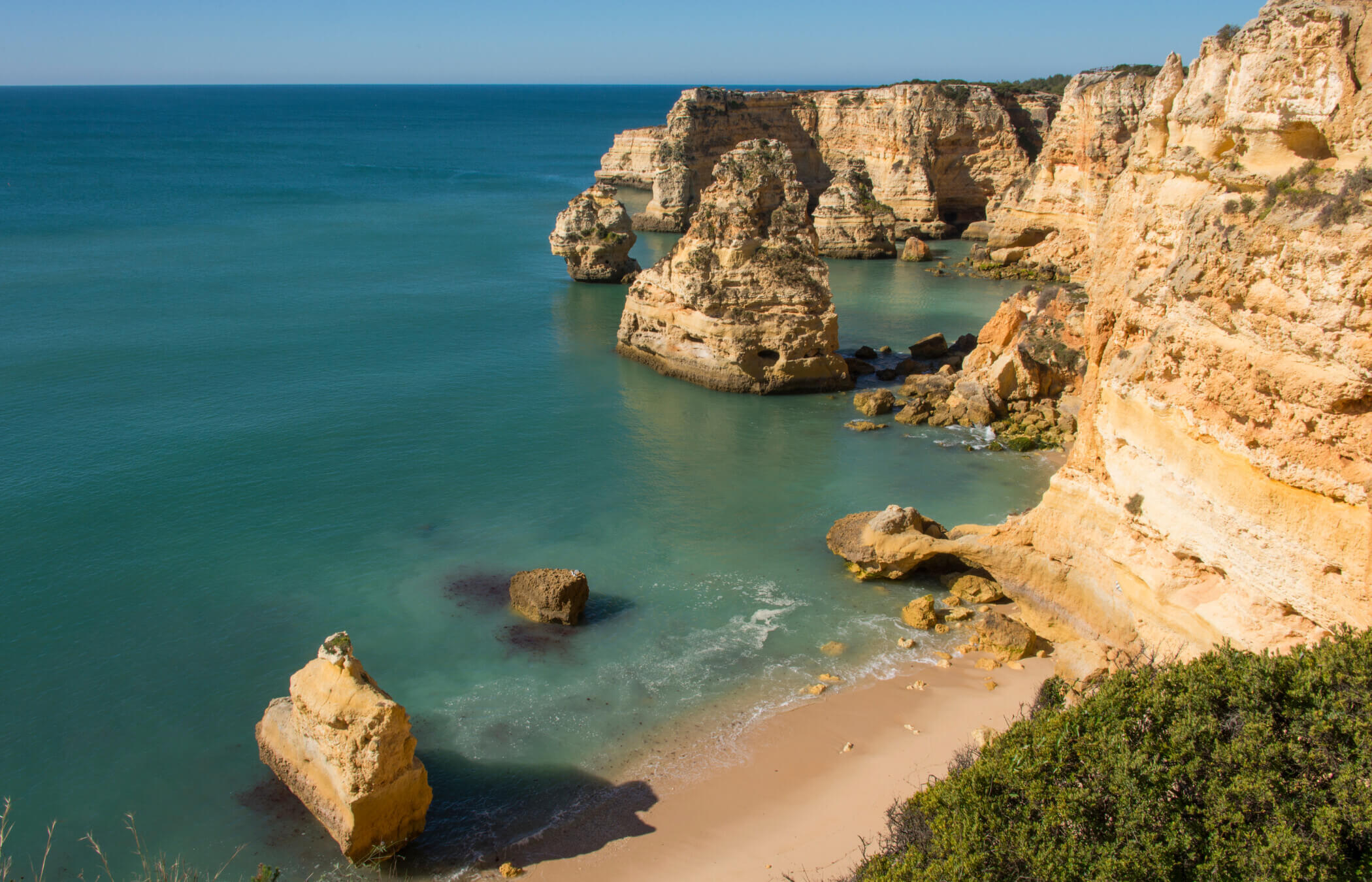 An der Praia da Marinha im „Goldenen Südwesten“ der Algarve stürzen sich goldene Klippen in das ruhige blaue Meer