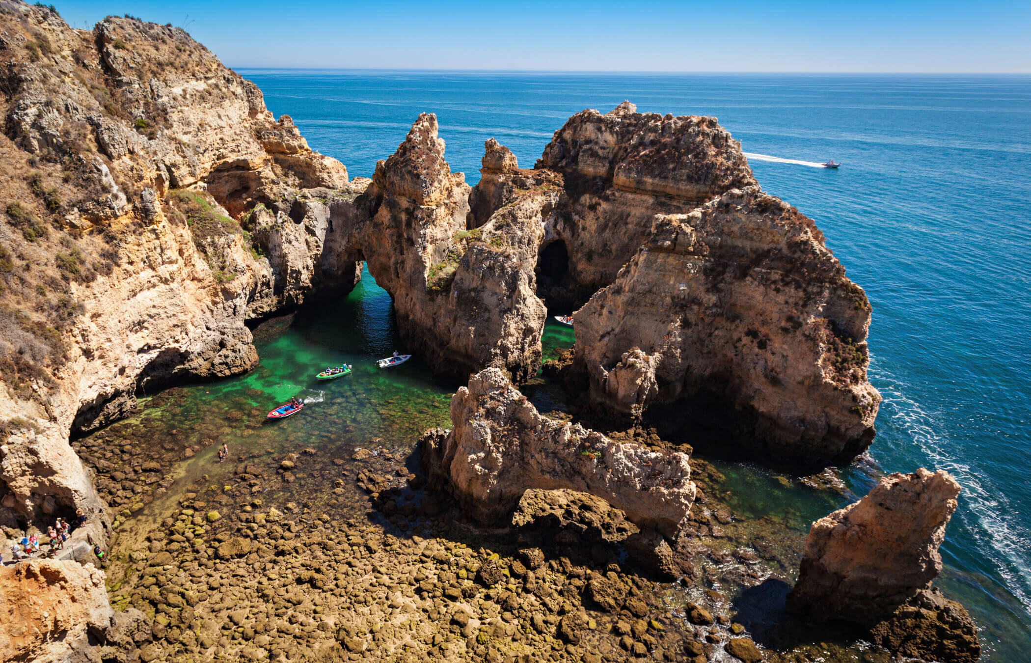 An der Ponta da Piedade an der portugiesischen Algarve ragen Felsbögen, Höhlen und hoch aufragende Felsnadeln dramatisch aus dem türkisfarbenen Wasser empor.