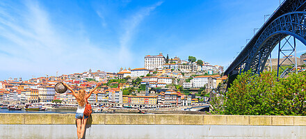 panorama view of porto cityscape, old town and dom luis bridge with woman traveler portugal