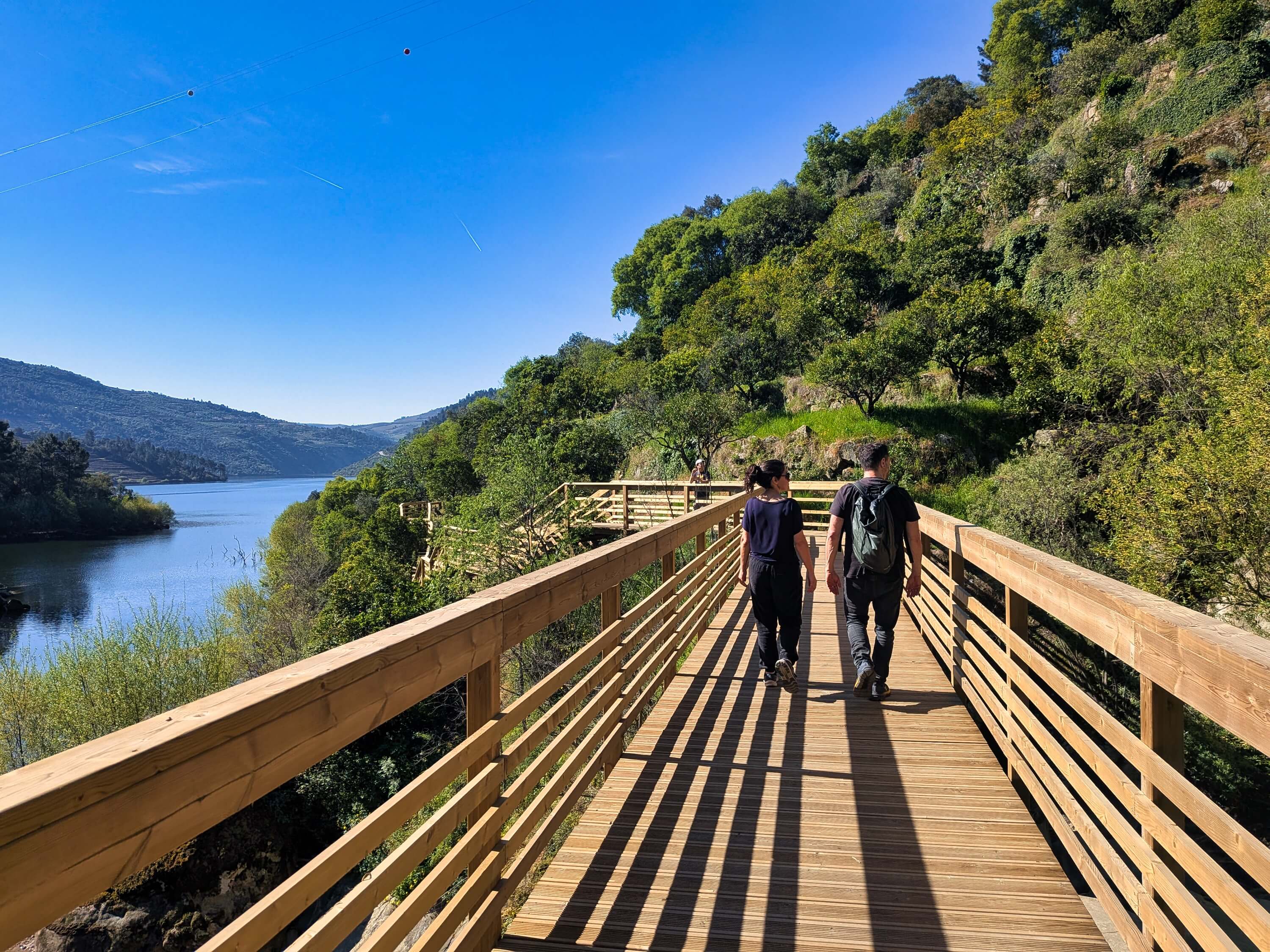 douro valley 2 hikers on wooden walkway near river pxl 20260406 093748259